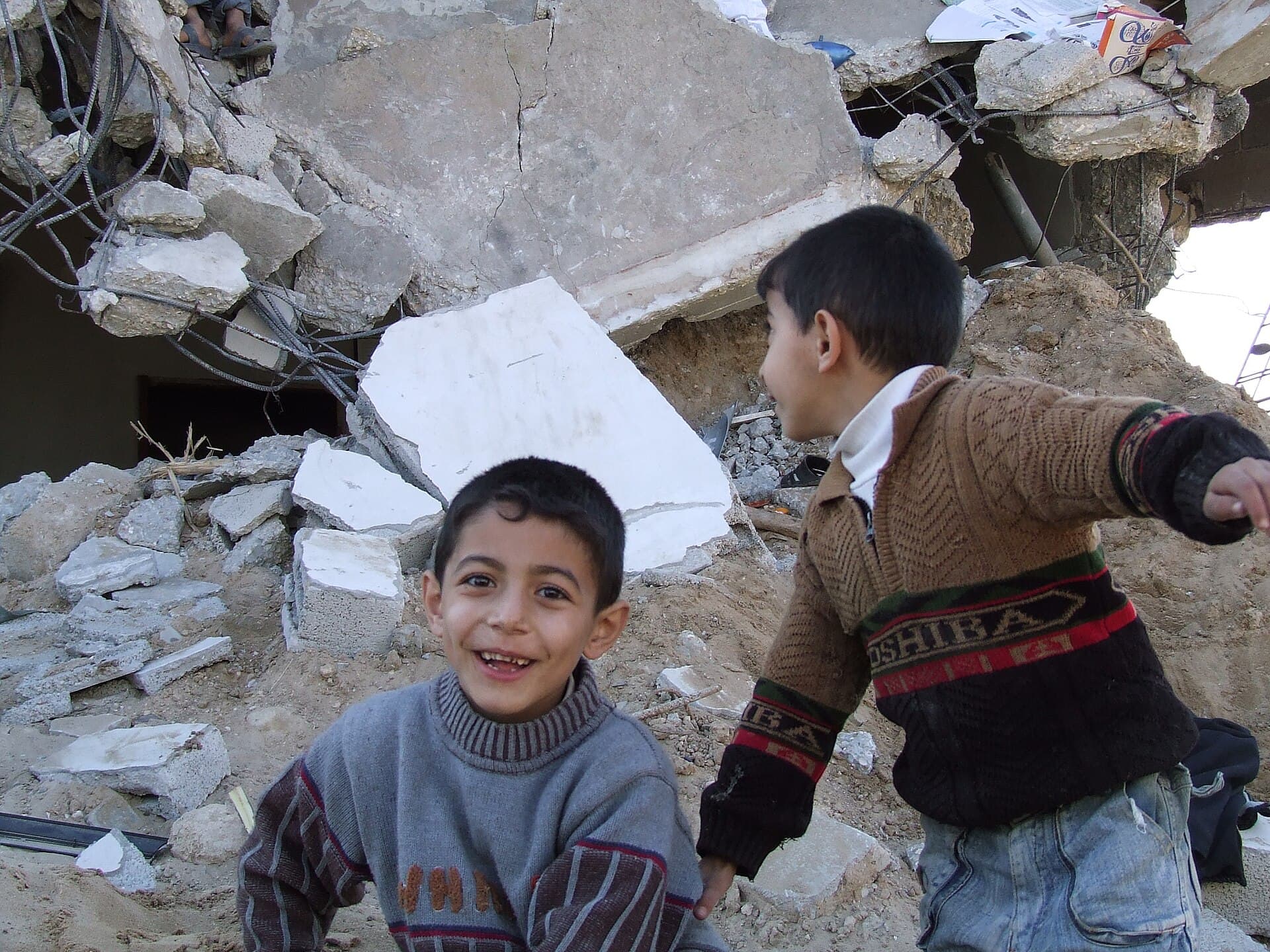 Two boys play beside the rubble of destroyed homes in Gaza